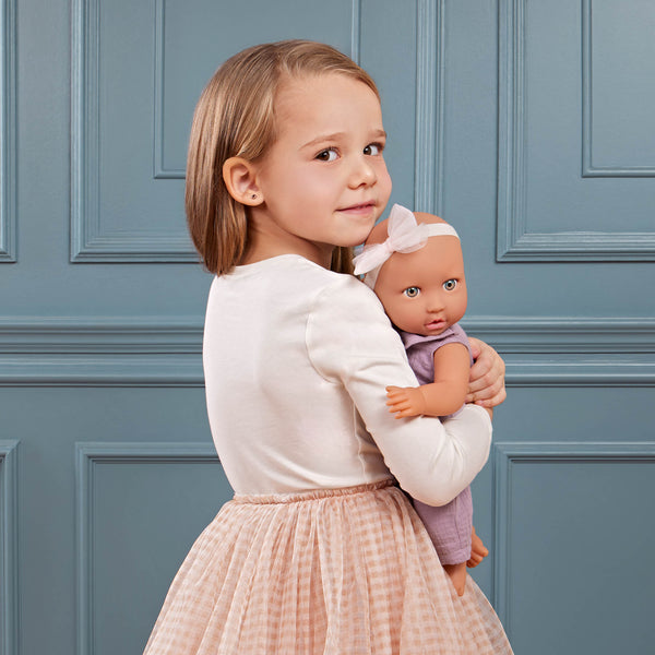 Babypuppe mit Schnuller im lila Musselinoutfit mit Stirnband