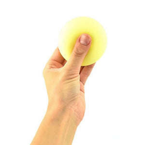 Hand drückt einen gelben Neon-Knautschball