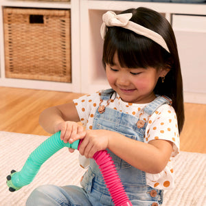 Mädchen spielt mit Battat Li'l Barn Buddies Sensorik-Röhren