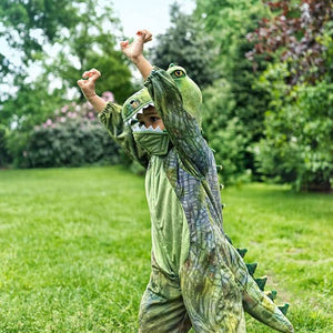 Kind im Dinosaurier-Kostüm T-Rex spielt auf der Wiese