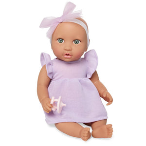 Babypuppe mit Schnuller – in einem violetten Kleid und mit einem Stirnband