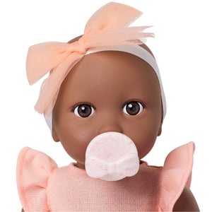Babypuppe mit Schnuller – in einem orangefarbenen Kleid und mit einem Stirnband