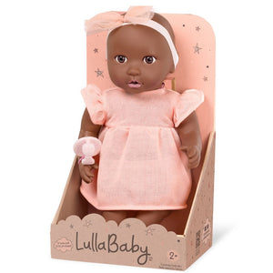 Babypuppe mit Schnuller – in einem orangefarbenen Kleid und mit einem Stirnband