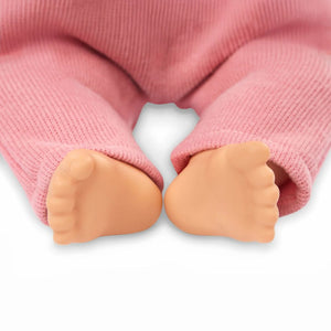 Baby-Puppe mit Schnuller, im Strampler und mit Stirnband