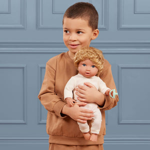 Baby-Jungenpuppe mit Haaren und Schnuller in einem zweiteiligen Outfit