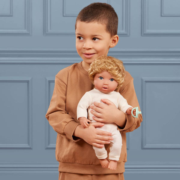 Baby-Jungenpuppe mit Haaren und Schnuller in einem zweiteiligen Outfit