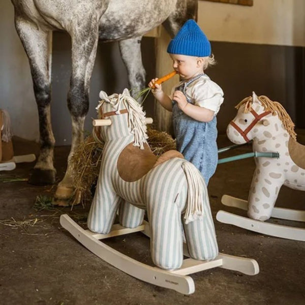 Kind mit Schaukelpferden der Kollektion AIDEN von Kid's Concept