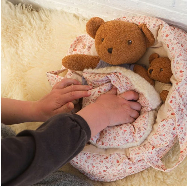 Kind deckt die Plüschbären im Schlafsack zu