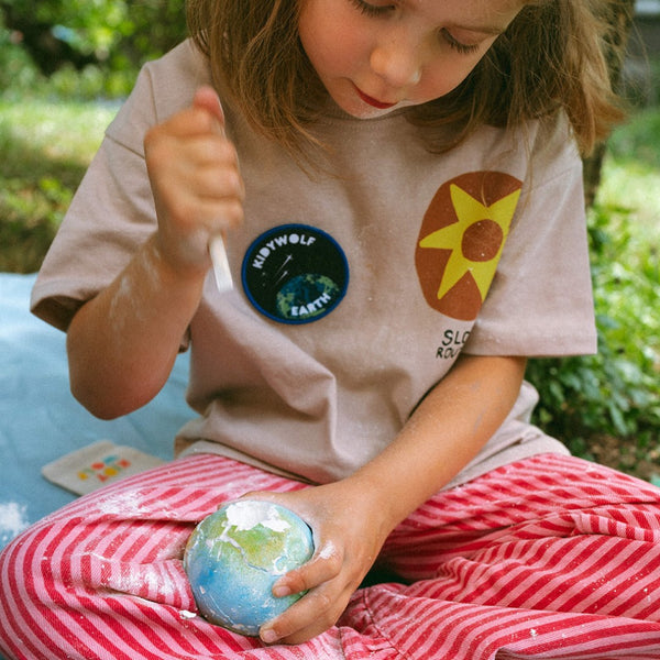 Kind mit Kidywolf Planet und Sammel-Pin