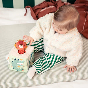 Baby spielt mit dem Activity-Würfel Löwe Jack von Lilliputiens