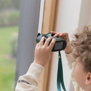 Ein Kind nutzt das Digitalmikroskop KidLupe, um Naturdetails durch das Fenster zu beobachten