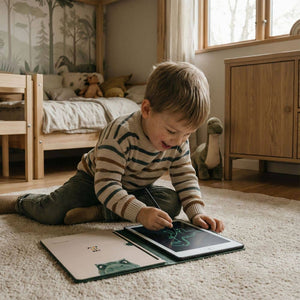 Kind benutzt ein Dinosaurier Malbuch Grafiktablett auf dem Boden zum Zeichnen und Spielen