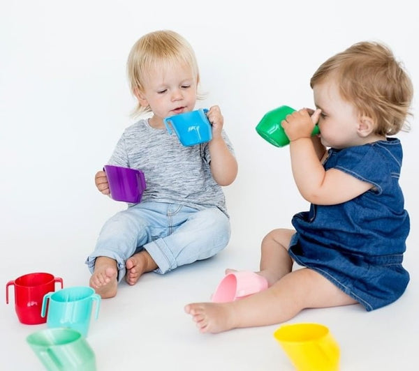 Kleine Kinder spielen mit bunten Kubeks von Bickiepegs Doidy Cup grau kaufen