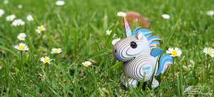 3D Öko Einhorn Puzzle in der Natur, umgeben von Blumen auf grüner Wiese