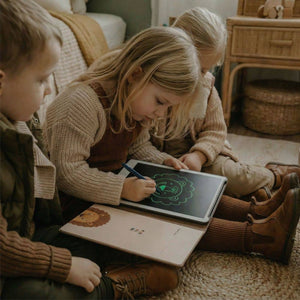 Kinder benutzen ein Grafiktablett für Kinder zum Zeichnen und Spielen in einem gemütlichen Raum