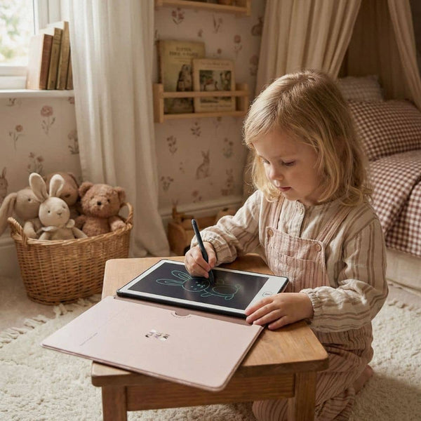 Kind malt mit Znikopis Grafiktablett für Kinder zeichnen in gemütlicher Umgebung