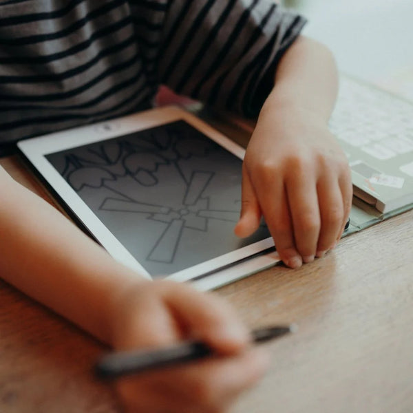 Grafiktablett Kidydraw Mini Dinosaurier mit kindlicher Hand auf dem Tisch beim Zeichnen