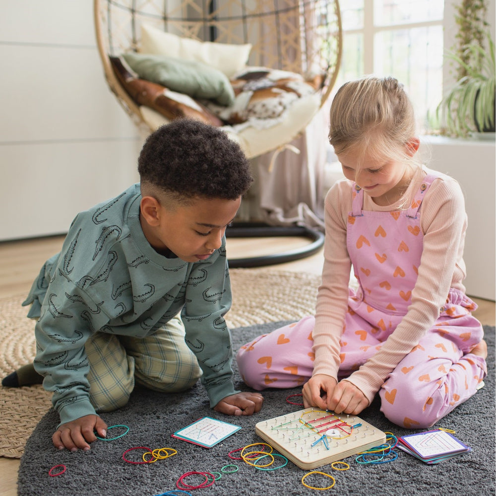 Kind hält Holz Geoboard für Kinder mit bunten Stiften und Gesichtsdesign in den Händen