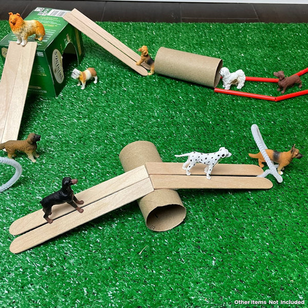 Hunde Spielfiguren Set von Safari Ltd. auf einem Spieluntergrund mit Holzleitern und Rohren