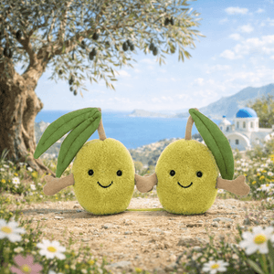 Zwei knuddelige Plüsch Oliven Jellycat mit fröhlichen Gesichtern in einer malerischen Landschaft