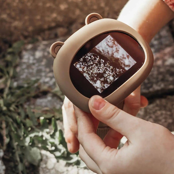 Kind, der ein KidLupe Kinder-Mikroskop kaufen hält, das ein Bild von Insekten zeigt