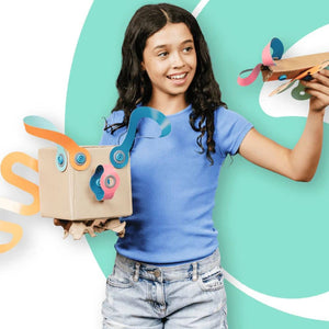 Mädchen zeigt Makedo kreative Bastelsets für Kinder mit bunten Bastelprojekten aus Karton