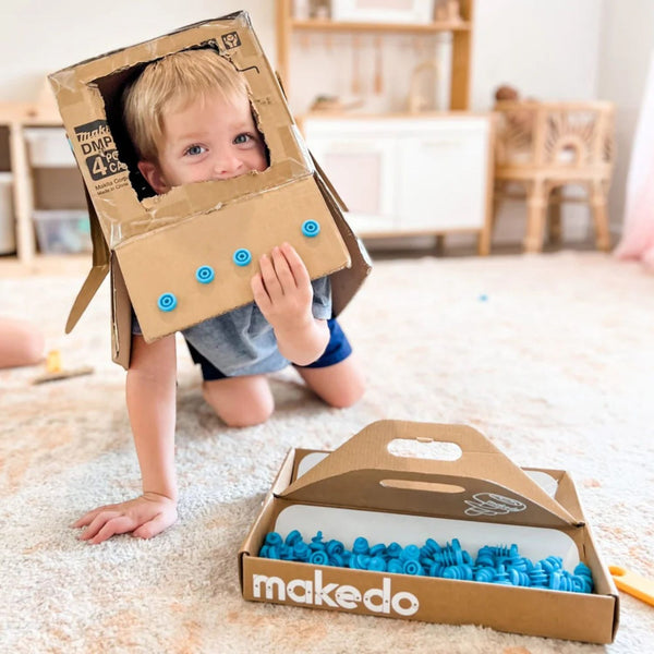 Kind spielt mit Makedo Werkzeugset und sicherer Kartonperforierroller Fold-Roller aus Karton