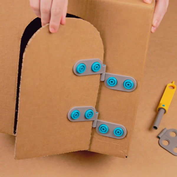 Makedo Spin-Scharnier-Set 6-tlg. aus Kunststoff befestigt an Wellpapp-Tür mit gelbem Werkzeug