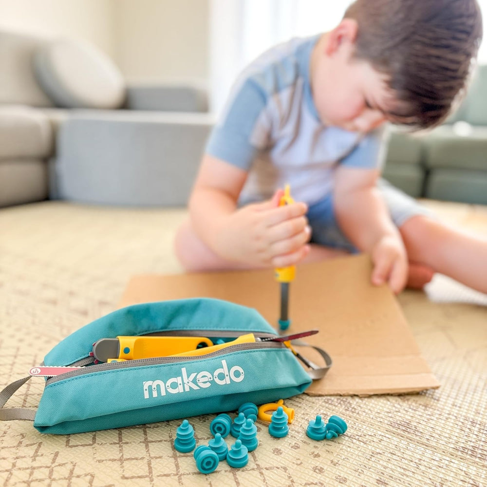 Makedo Tasche für Werkzeuge und Schrauben mit gelbem Werkzeug und blauen Schrauben vor spielendem Kind
