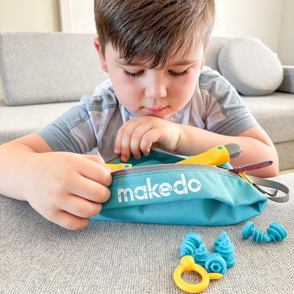 Makedo Tasche für Werkzeuge und Schrauben mit gelbem Werkzeug und blauen Schrauben vor spielendem Kind