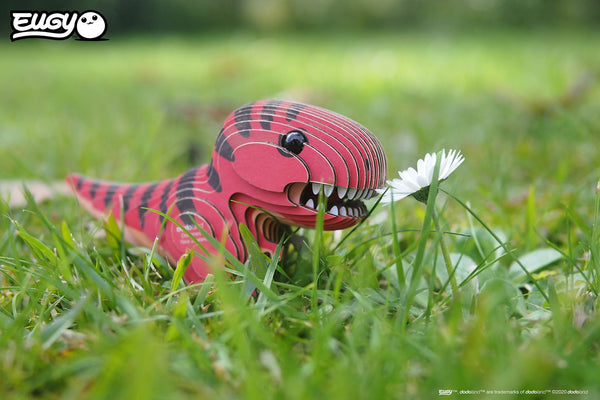 Öko 3D Puzzle Tyrannosaurus in bunten Farben, der in einer Blumenwiese steht