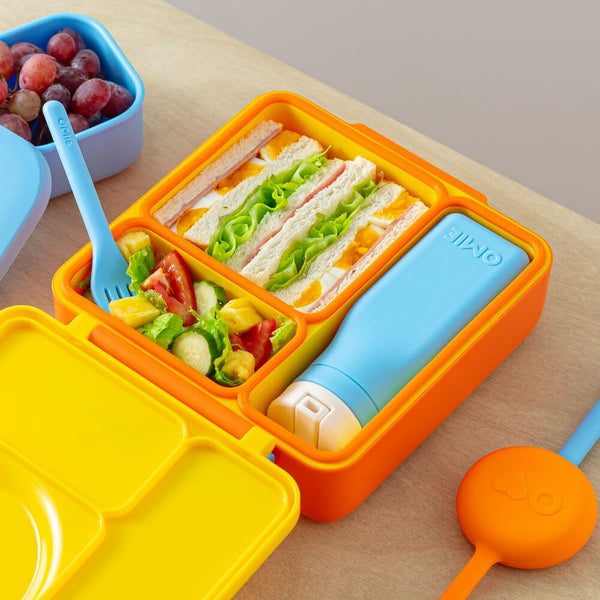 Lunchbox mit Thermosbehälter OmieBox – Sunshine orange mit Sandwich, Salat und Thermosflasche auf Holztisch