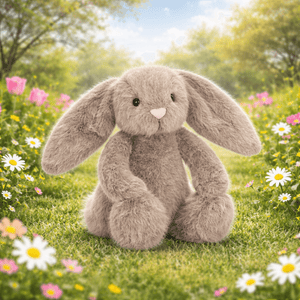 Jellycat Plüschhase Flufflet Fawn sitzt in einer blühenden Wiese umgeben von Blumen