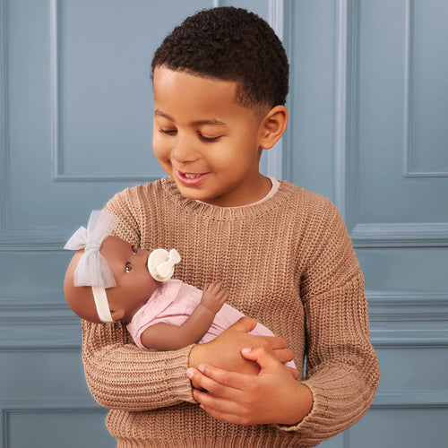 Babypuppe mit Schnuller im rosa Musselinoutfit mit Stirnband