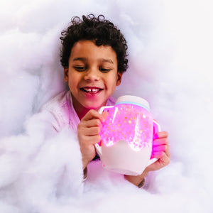 Kind hält Zabawka progresywna von Glo Pals mit Sensorik-Glas zum Befüllen mit Wasser – grau