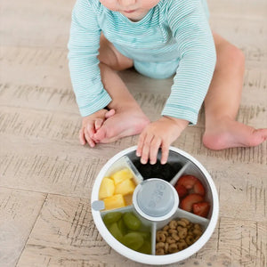 Kind spielt mit Gobe Snack Spinner Snackbehälter - Macaron Blue mit bunten Snacks