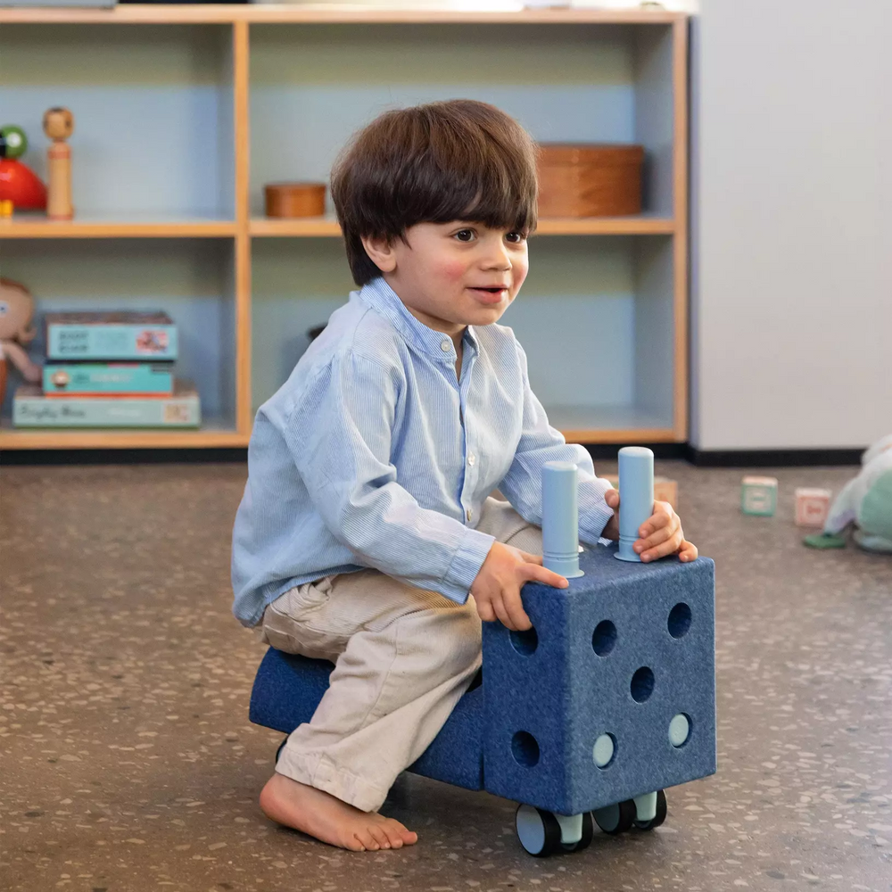 Kinder spielen mit MODU Klocki auf einem Blauen Spielzeug mit Rollen, ideal für kreative Aktivitäten