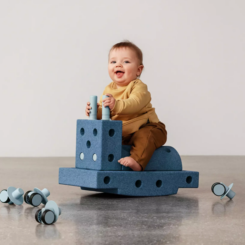 Kinder spielen mit MODU Klocki auf einem Blauen Spielzeug mit Rollen, ideal für kreative Aktivitäten